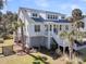 Beautiful two-story home with lush landscaping, multiple decks, and a well-manicured lawn at 129 Sparrow Dr, Isle of Palms, SC 29451