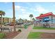 Quaint commercial streetscape with a Ben & Jerry's shop, palm trees, and sidewalk seating, offering a vibrant atmosphere at 129 Sparrow Dr, Isle of Palms, SC 29451