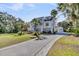 Stylish home with white exterior, manicured lawn, and long driveway at 129 Sparrow Dr, Isle of Palms, SC 29451