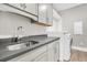 Well-equipped laundry room with gray countertops, shaker cabinets, and modern stainless steel sink at 129 Sparrow Dr, Isle of Palms, SC 29451