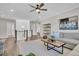 Open-concept living room with a large ceiling fan, gray sofa, and hardwood floors at 129 Sparrow Dr, Isle of Palms, SC 29451