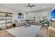 Cozy living room with a large sectional sofa, shelving, and hardwood floors illuminated by natural light at 129 Sparrow Dr, Isle of Palms, SC 29451
