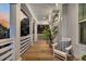 Inviting porch with a wooden deck, white columns, seating, and decorative lanterns at 129 Sparrow Dr, Isle of Palms, SC 29451