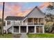 Stunning rear view of a two-story coastal home with a spacious screened-in porch at 129 Sparrow Dr, Isle of Palms, SC 29451
