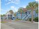 Street view of stores including a blue building with a copper-colored roof and palm trees at 129 Sparrow Dr, Isle of Palms, SC 29451