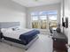 Bright bedroom with large windows, gray bed frame, and desk area with ergonomic chair at 145 Pier View St # 403, Charleston, SC 29492
