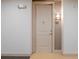 Close up of a neutral colored apartment entry door with a peephole and a unit number sign at 145 Pier View St # 403, Charleston, SC 29492