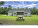 The spacious backyard features a screened porch, wooden picnic table and a well-maintained lawn, perfect for outdoor activities at 1721 Pimlico Blvd, Moncks Corner, SC 29461