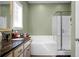 Well-lit bathroom featuring a soaking tub, walk-in shower, and a vanity with a dark countertop at 188 Donning Dr, Summerville, SC 29483