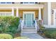 Welcoming front porch with blue door, white railings and meticulously maintained landscaping at 188 Donning Dr, Summerville, SC 29483