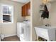 This laundry room has a washer, dryer, utility sink, and dark brown cabinets at 188 Donning Dr, Summerville, SC 29483