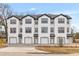 Modern townhome complex with white exteriors, black trim, and individual garages at 2191 Helm Ave, North Charleston, SC 29405