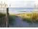 Path to a peaceful beach with sea oats and a wooden fence framing the ocean view, inviting tranquility at 280 Driftwood Ln, Edisto Beach, SC 29438
