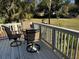 Outdoor deck featuring a table, chairs, and a view of the surrounding community landscape at 280 Driftwood Ln, Edisto Beach, SC 29438