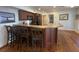 Open kitchen featuring a breakfast bar, dark cabinetry, and wood floors at 280 Driftwood Ln, Edisto Beach, SC 29438