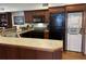 Well-equipped kitchen with wood cabinets, modern appliances, and breakfast bar at 280 Driftwood Ln, Edisto Beach, SC 29438