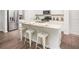 Bright kitchen island featuring granite countertops, white cabinets, and modern stools at 306 Pine Crest View Dr, Summerville, SC 29486