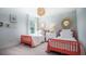 This cozy bedroom features two charming red twin beds, complemented by a white dresser and soft, natural light at 308 Pine Crest View Dr, Summerville, SC 29486