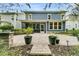 View of the blue two-story home featuring a screened in patio and landscaped stone garden at 331 Weston Hall Dr, Summerville, SC 29483