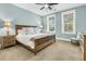 Serene bedroom with a wooden bed frame, soft lighting, and two windows at 331 Weston Hall Dr, Summerville, SC 29483