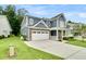 Charming two-story home featuring a stone facade, blue siding, and a spacious driveway at 331 Weston Hall Dr, Summerville, SC 29483