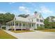 The beautiful white home offers southern charm with a spacious wrap-around porch at 331 Weston Hall Dr, Summerville, SC 29483