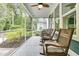 Relaxing screened porch with rocking chairs and views of the landscaped backyard, perfect for enjoying the outdoors at 331 Weston Hall Dr, Summerville, SC 29483