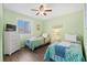 This cozy bedroom features 2 twin beds, a ceiling fan, and wood-look flooring at 46 Mariners Cay Dr, Folly Beach, SC 29439