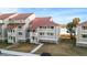 Attractive condo exterior with red metal roof, white trim, and balcony offering views of the surrounding area at 46 Mariners Cay Dr, Folly Beach, SC 29439