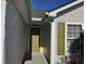 Close up of the home's entrance with a green front door, green shutters and tan siding at 5082 Westview St, North Charleston, SC 29418