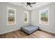 Bright bedroom featuring three large windows offering wooded views and wood laminate flooring at 5585 Wire Road, Branchville, SC 29432
