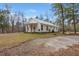 Sprawling white home on a large lot featuring covered porches, gravel drive, and wooded surroundings at 5585 Wire Road, Branchville, SC 29432