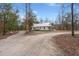 View of house from the driveway surrounded by trees and a lush green landscape at 5585 Wire Road, Branchville, SC 29432
