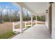 Concrete front porch with white columns, wood railing, a concrete walkway, and views of surrounding landscape at 5585 Wire Road, Branchville, SC 29432