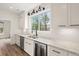 Kitchen counter with double sink, wine cooler, white cabinets, and outside view at 5585 Wire Road, Branchville, SC 29432
