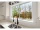 Kitchen sink with nature view, white cabinets, black faucet, and stainless steel appliances at 5585 Wire Road, Branchville, SC 29432
