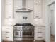 Bright kitchen features stainless steel appliances, range hood, white cabinetry, and marble countertops at 5585 Wire Road, Branchville, SC 29432