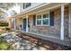 Charming front porch with chairs, a blue door with wreaths, and decorative plants at 5803 W Lakeside Dr, Hanahan, SC 29410