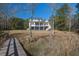 Expansive backyard featuring a staircase from the deck, and serene views of the surrounding natural landscape at 7527 Ladys Secret Ln, Awendaw, SC 29429