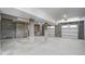 Large unfinished basement featuring concrete block walls, columns, and a garage door at 7527 Ladys Secret Ln, Awendaw, SC 29429