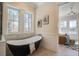 Bright bathroom features a modern soaking tub with serene views from the windows and access to the bedroom at 7527 Ladys Secret Ln, Awendaw, SC 29429