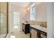Bathroom with dual dark wood vanities and a bright window at 7527 Ladys Secret Ln, Awendaw, SC 29429
