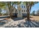 Beautiful two-story home with stairs leading up to porch and mature trees at 7527 Ladys Secret Ln, Awendaw, SC 29429