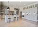 A modern kitchen featuring white cabinetry, a center island with seating, pendant lighting, and open shelving at 7527 Ladys Secret Ln, Awendaw, SC 29429
