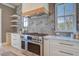 Updated kitchen with stainless steel appliances, custom hood, open shelving, and light fixtures at 7527 Ladys Secret Ln, Awendaw, SC 29429