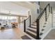 Spacious living room with hardwood floors flowing into a large window and open stairway at 7527 Ladys Secret Ln, Awendaw, SC 29429