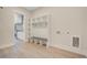 Mudroom featuring custom cabinets with storage bench and view to the kitchen at 7527 Ladys Secret Ln, Awendaw, SC 29429