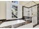 Elegant bathroom featuring a soaking tub with marble countertops and a glass-enclosed shower at 87 Dungannon Hall, Kiawah Island, SC 29455