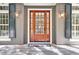 Elegant front door featuring sidelights and transom window and decorative sconces and shutters at 87 Dungannon Hall, Kiawah Island, SC 29455
