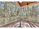 Outdoor porch with wood floors and porch railings surrounded by many trees at 87 Dungannon Hall, Kiawah Island, SC 29455